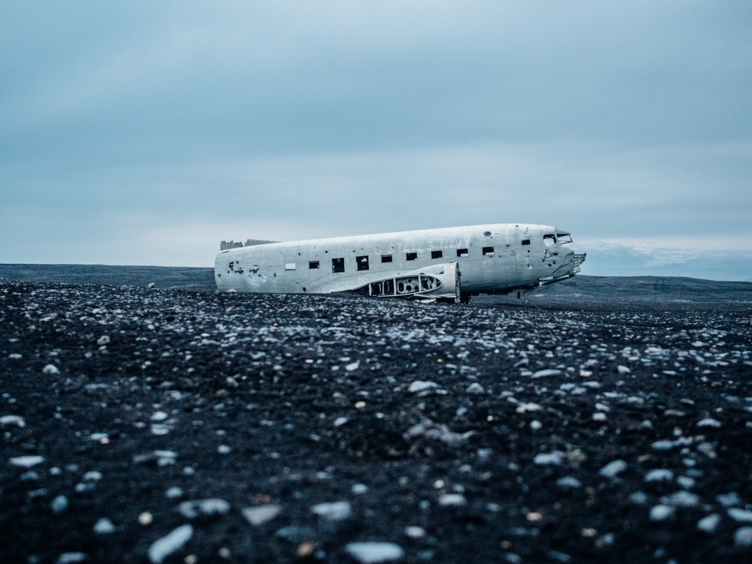 (Image of plane wreckage in an arctic field.)